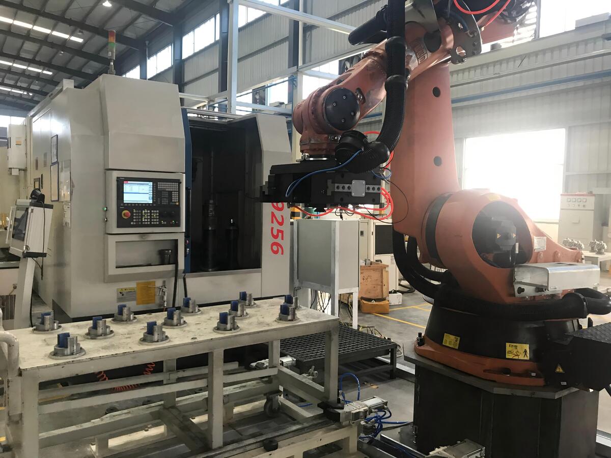 Seamless Robot Integration For Hmlv Automated gear chamfering machine integrated with a robotic arm for automatic loading and unloading on a production line.